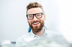 Smiling man, showing his new dental implant restorations