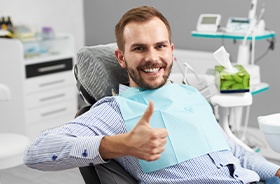 Man in dental chair giving thumbs up