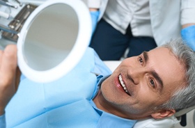 Man admiring his smile after receiving tooth-colored filling
