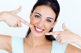 Woman pointing to flawless smile