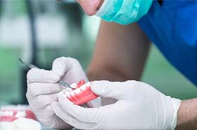 Close up of dental lab technician carefully working on dentures