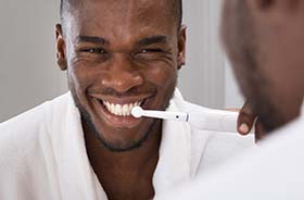 Man flossing to prevent dental emergencies in Branford