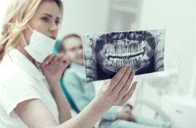 Dentist carefully reviewing patient’s X-ray