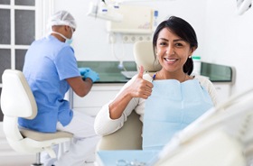 Patient giving thumbs up for successful implant salvage treatment