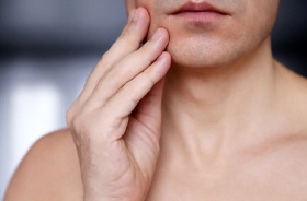 Man touching jaw, concerned about his oral health symptoms