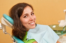 Female patient smiling after successful implant salvage treatment