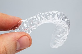 Hand holding a clear aligner