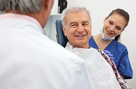 Older man in dental chair smiling