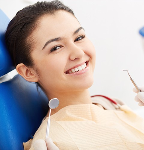 Smiling young woman sitting in dental chair