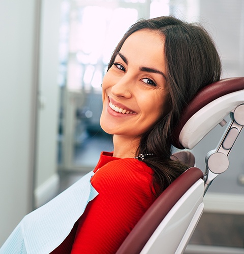 Woman in dental chair smiling at dentist