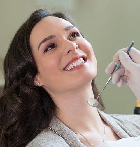 Woman smiling right before receiving a dental exam