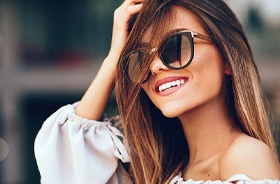 Woman in sunglasses enjoying benefits of smile makeover