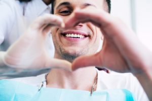dental patient and dentist using hands to make heart shape