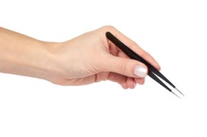 hand holding pair of black tweezers against white background