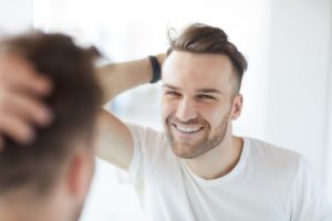 Man admiring his smile after receiving tooth-colored fillings Branford, CT