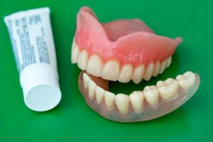 Dentures next to tube of adhesive cream