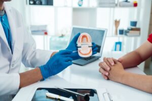 Dentist and patient sitting at desk during consultation 